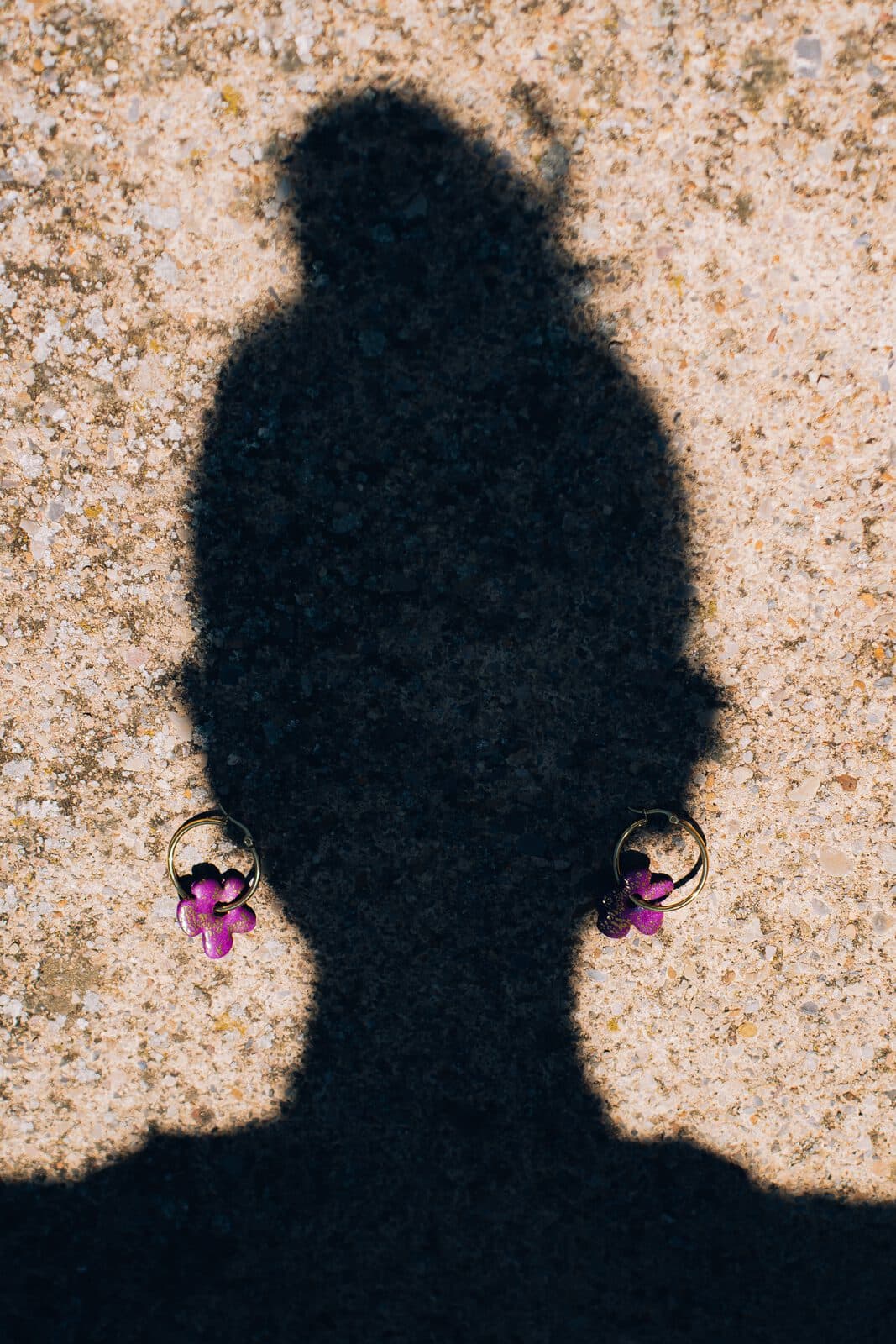 Sombra de una modelo con pendientes sobre una pared de cal